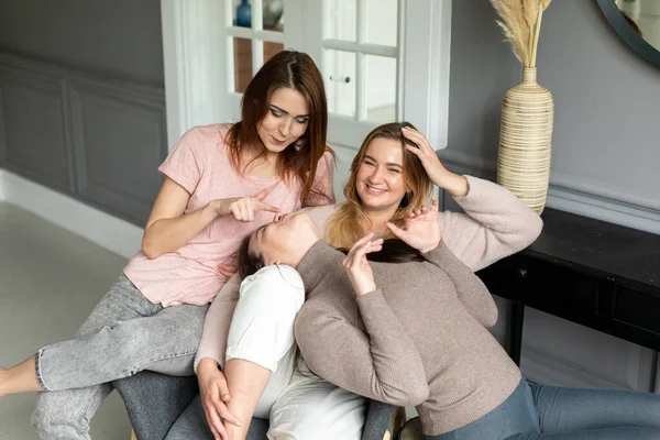Meninas amigas sentar em casa em uma cadeira e conversar. meninas passar o tempo juntos em casa — Fotografia de Stock