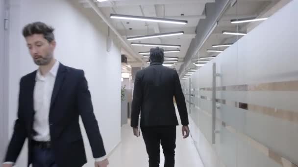 Empresario africano enfocado caminando en la reunión en la oficina. Gerente afroamericano caminando por el pasillo de oficinas. Primer plano hombre de negocios afro serio va a la reunión en el centro de negocios. — Vídeos de Stock