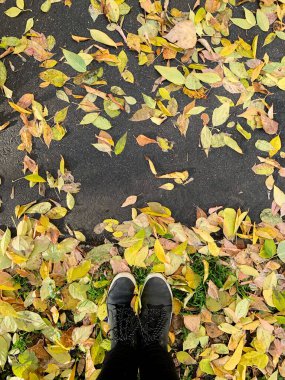 Sonbahar yapraklarında çizmeli bacakların kavramsal görüntüsü