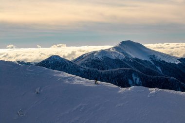 Dağlarda kayakçı, arka planda bulut denizi
