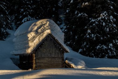 Dağ kulübesi karla kaplı.