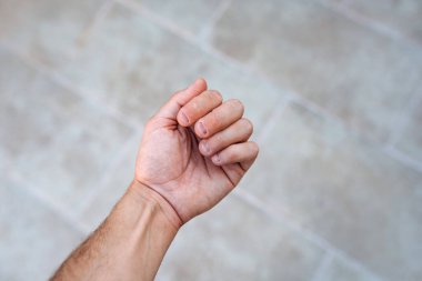 Tırnakları yenmiş ve çirkin bir adamın eli. Ellere kötü bakılıyor