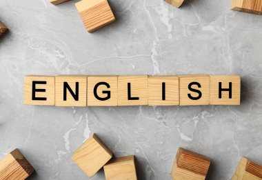Gri mermer zemin üzerinde kelime ENGLISH ile ahşap küpleri düz yatıyordu