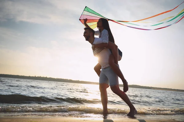 Casal Feliz Brincando Com Pipa Praia Perto Mar Pôr Sol — Fotografia de Stock