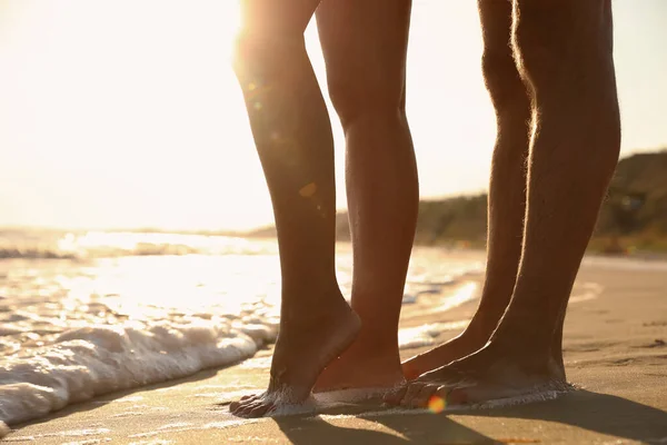 日没時に海の近くの砂浜のカップル 足の閉鎖 — ストック写真
