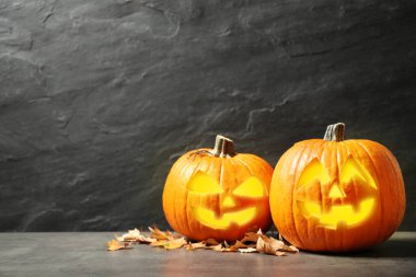 Korkunç balkabağı Jack O 'Lantern balkabağı ve siyah arka planda düşen yapraklar, mesaj için yer. Cadılar Bayramı Dekorasyonu