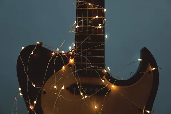 Gitaar Met Gloeiende Elfenlichtjes Donkere Achtergrond Close Kerstmuziek — Stockfoto