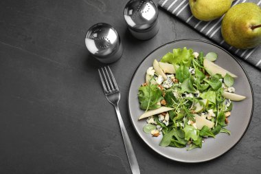 Siyah masada servis edilen armut dilimli lezzetli bir salata. Metin için boşluk