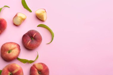 Açık pembe arka planda taze şeftali, düz. Metin için boşluk