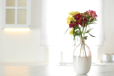 Mutfaktaki masada güzel çiçekli vazo, mesaj için yer. İç tasarımın stil ögesi