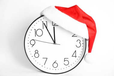 Noel Baba şapkalı saat beyaz arka planda gece yarısına beş dakika kaldığını gösteriyor. Yeni yıl geri sayımı