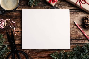 Noel dekorlu düz kompozisyon ve ahşap masa üzerinde boş kart. Metin için boşluk