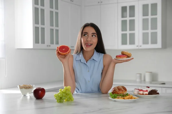 Mujer Eligiendo Entre Pomelo Rosquillas Cocina —  Fotos de Stock