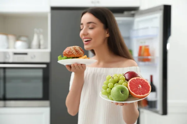 Kvinna Väljer Mellan Frukt Och Burgare Med Pommes Frites Nära — Stockfoto