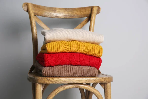 木製の椅子に折り畳まれたニットセーターのスタック — ストック写真
