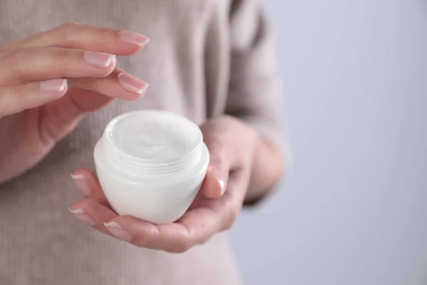 Mujer Joven Sosteniendo Tarro Crema Sobre Fondo Gris Primer Plano —  Fotos de Stock