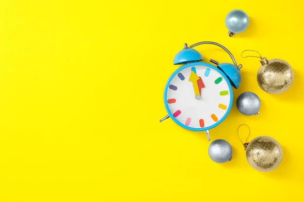 黄色の背景に目覚まし時計やお祝いの装飾 テキストのためのスペースとフラットレイアウト 新年のカウントダウン — ストック写真