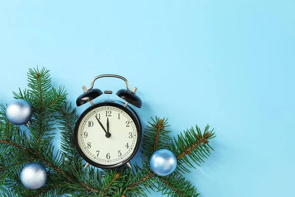 ライトブルーの背景に目覚まし時計や装飾されたモミの枝は テキストのためのスペースとフラットレイアウト 新年のカウントダウン — ストック写真