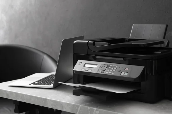 室内灰色桌子上的新型现代打印机和笔记本电脑 — 图库照片