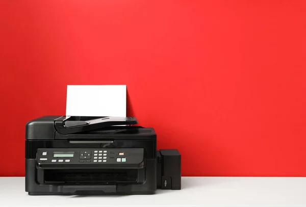 Modern printer with paper on red background. Space for text