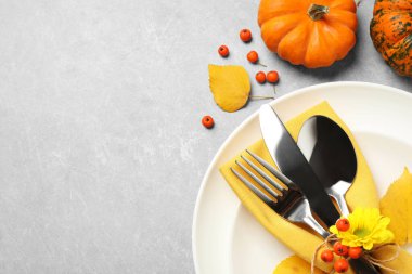 Açık gri arka planda balkabakları olan mevsimlik masa ayarları, düz yatış. Şükran Günü