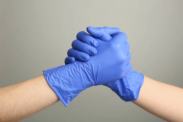Människor Medicinska Handskar Skakar Hand Grå Bakgrund Närbild — Stockfoto