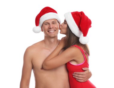 Beyaz arka planda Noel Baba şapkalı mutlu çift. Noel tatili