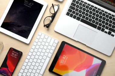 MYKOLAIV, UKRAINE - 27 Ağustos 2020: iPhone 11, MacBook dizüstü bilgisayarı ve iPad tabletleriyle ahşap masa üzerinde düz kompozisyon