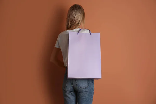 Mujer Con Bolsa Papel Sobre Fondo Marrón Claro Vista Trasera — Foto de Stock