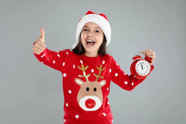 Gri Arka Planda Çalar Saati Olan Noel Baba Şapkalı Kız — Stok fotoğraf