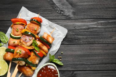 Sebzeli tavuk şiş kebap ve siyah ahşap masada ketçap. Metin için boşluk