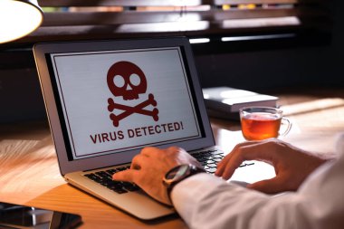 İş yerindeki virüs saldırısı hakkında uyarı içeren dizüstü bilgisayar kullanan adam, yakın plan