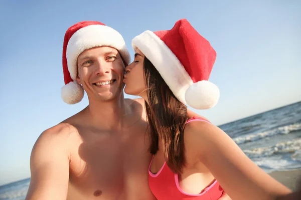 Boldog Pár Mikulás Sapkával Akik Együtt Szelfiznek Parton Karácsonyi Vakáció — Stock Fotó