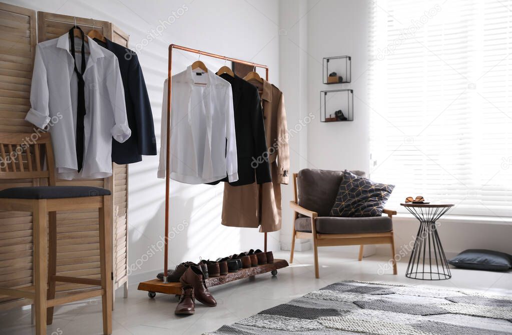 Dressing room interior with clothing rack and armchair