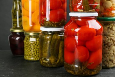 Gri masada turşulu sebze kavanozları, yakın plan.