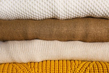 Arka plan olarak katlanmış süveter yığını, yakın plan