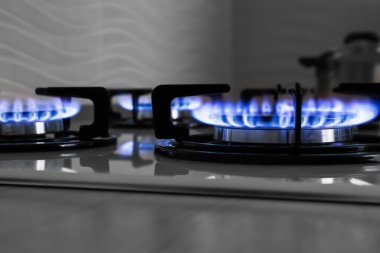 Mutfakta yanan mavi alevleri olan modern gaz ocağı.