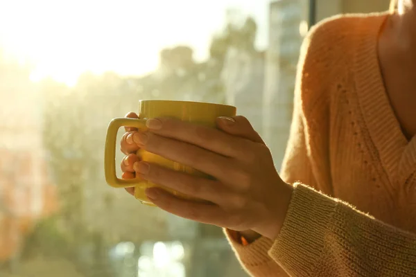 Holding Csésze Tea Mellett Ablak Otthon Közelkép — Stock Fotó