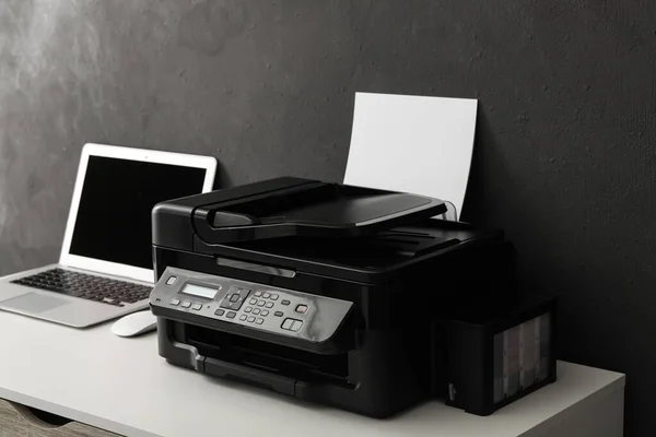 New modern printer and laptop on white table