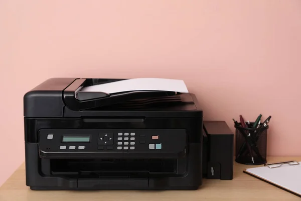 New modern printer and office supplies on wooden table
