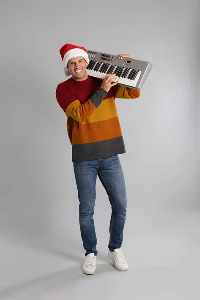 Man Santa Hat Грає Синтезаторі Світлому Сірому Фоні Різдвяна Музика — стокове фото