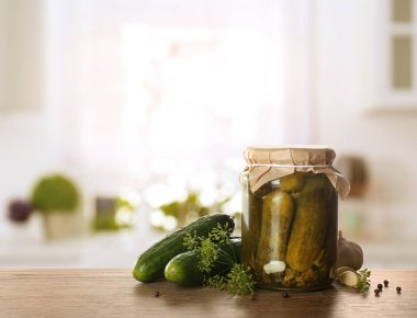 Mutfaktaki ahşap masada salatalık turşulu kavanoz. Metin için boşluk