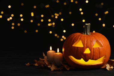 Balkabağı Jack O 'Lantern, mumlar ve sonbahar yaprakları bulanık arka planda, mesaj için yer var. Cadılar Bayramı Dekorasyonu