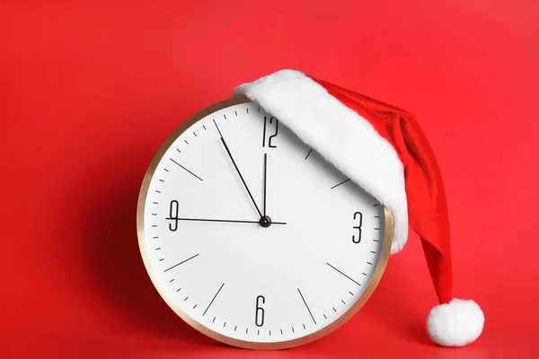 Годинник Капелюхом Санта Показує Ять Хвилин Півночі Червоному Тлі Новорічний — стокове фото