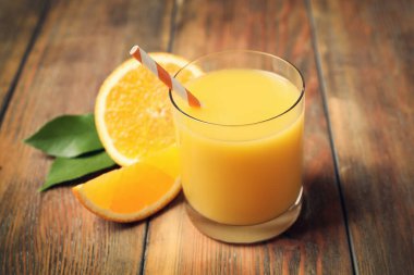 Bir bardak portakal suyu ve ahşap masada taze meyveler, yakın plan.