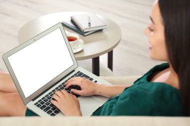 Oturma odasında dizüstü bilgisayarla çalışan genç bir kadın, ellere odaklan. Merkez ofis kavramı