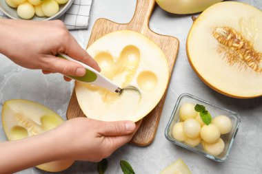 Gri masada kavun köftesi yapan bir kadın.