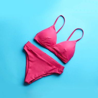Açık mavi arkaplanda güzel pembe bikini, üst manzara