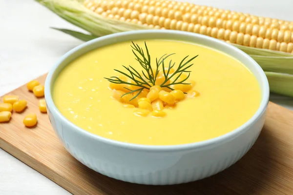Delicious creamy corn soup on white table