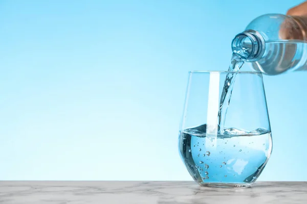 Despeje Água Garrafa Vidro Sobre Fundo Azul Espaço Para Texto — Fotografia de Stock